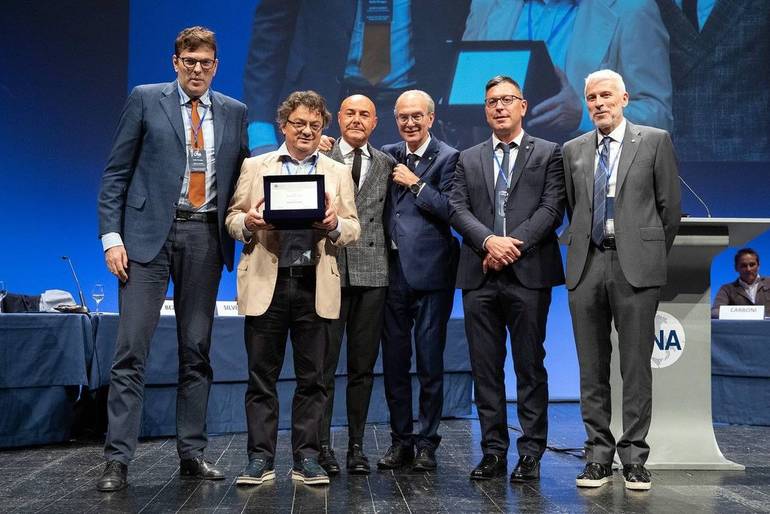 Foto della premiazione all’assemblea regionale di CNA. Cesare Testi è premiato da Lorenzo Zanotti e Franco Napolitano, rispettivamente presidente e direttore generale di CNA Forlì-Cesena